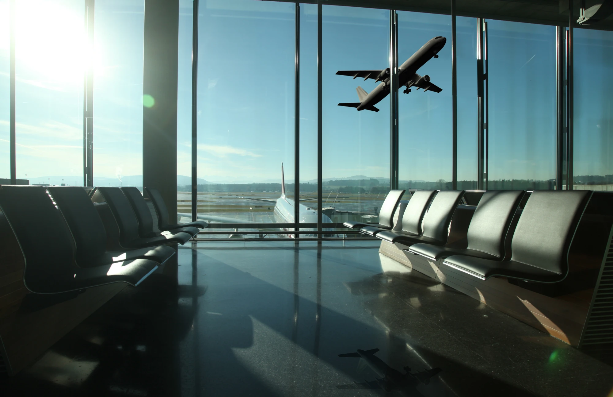 Sala de espera de aeropuerto con avión despegando